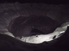 Ночь в ноябре спускается быстро. На стене кратера заметен огонек фонарика, закрепленных на шлеме альпиниста.