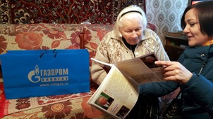 Фронтовая медсестра Зоя Николаевна Сычева (слева) рассматривает фотоальбом "Поколению победителей — с любовью"