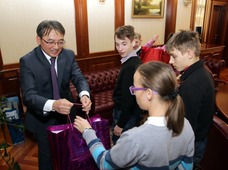 Дмитрий Люгай вручил каждому из юных гостей новогодний подарок ,..